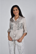 Load image into Gallery viewer, The Charise Champagne Blouse is made of a luxurious satin fabric that features chic sequin sparkle pockets. It also includes a button-down design with tab roll sleeves, as well as an elastic waistband with ties for an ideal fit.  Color- Champagne. Sequin pockets. Roll tab sleeves. Button down. Collared.
