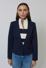 Load image into Gallery viewer, Woman wearing a navy blazer with a striped dickey and blue jeans against a plain background.
