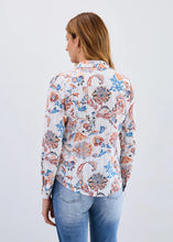 Load image into Gallery viewer, Woman wearing a floral-patterned shirt and jeans against a white background.
