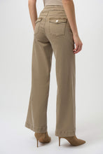 Load image into Gallery viewer, Model wearing warm taupe wide-leg jeans with button detailing on back pockets and taupe boots against a white background.
