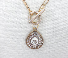 Load image into Gallery viewer, Experience a true rarity with this Clemantine necklace featuring a beautiful Chanel vintage teardrop zipper pull adorned with dazzling crystals. The teardrop design is complemented by a white teardrop base and a striking CC logo at its center. Don&#39;t miss the chance to own this stunning and one-of-a-kind piece.

