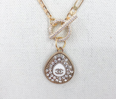 Experience a true rarity with this Clemantine necklace featuring a beautiful Chanel vintage teardrop zipper pull adorned with dazzling crystals. The teardrop design is complemented by a white teardrop base and a striking CC logo at its center. Don't miss the chance to own this stunning and one-of-a-kind piece.