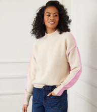 Load image into Gallery viewer, Woman wearing a sand and pink colorblock sweater and jeans against a white wall.

