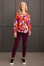 Load image into Gallery viewer, Steal the spotlight in this vibrantly printed blouse cut from flowy challis fabric with a hint of stretch. The popover v-neck, highlighted by delicate fabric ties, features a shirttail hem and long sleeves with elastic cuffs, completing the design. It seamlessly adds sophisticated style and vibrant color to your ensemble.
