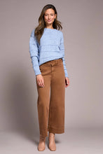 Load image into Gallery viewer, Woman wearing a light blue sweater. brown pants and tan boots against a neutral background.
