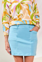 Load image into Gallery viewer, Model wearing a colorful floral blouse and aqua skort against a neutral background.
