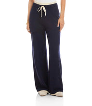 Load image into Gallery viewer, Navy blue wide-leg pants with a cream trim and drawstring and tennis shoes worn by a model against a white background.
