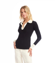 Load image into Gallery viewer, Woman wearing a black sweater with white collar and cuffs and jeans against a white background.
