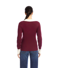 Load image into Gallery viewer, Woman wearing a burgundy sweater with a white collar and jeans against a white background.
