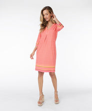 Load image into Gallery viewer, This timeless dress is a customer favorite. This season it is offered in a gorgeous coral color with timeless chain print and cute beading along the v-neckline. The dress is approximately knee length and has a three-quarter length sleeve.
