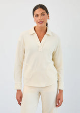 Load image into Gallery viewer, Woman wearing small gold hoop earrings, creme corduroy long sleeve, V-neck top and matching pant against a neutral background.
