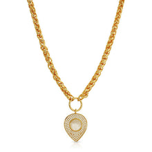 Load image into Gallery viewer, A gold chain necklace with a teardrop-shaped pendant featuring a central round white stone surrounded by small clear stones, set against a plain white background.
