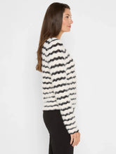 Load image into Gallery viewer, Woman wearing a black and white striped fuzzy sweater and black pants against a white background.

