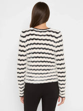 Load image into Gallery viewer, Woman wearing a black and white striped fuzzy sweater and black pants against a white background.

