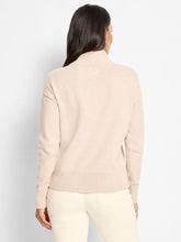 Load image into Gallery viewer, Woman wearing a beige sweater and white pants against a light gray background.
