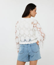 Load image into Gallery viewer, Woman wearing an off-white crochet cardigan over a white tank and blue jean short against a white background.

