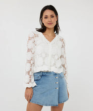 Load image into Gallery viewer, Woman wearing an off-white crochet cardigan over a white tank and blue jean mini skirt against a white background.
