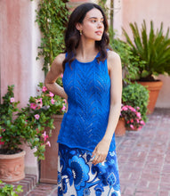 Load image into Gallery viewer, Woman wearing a blue sleeveless top with a floral patterned skirt in an outdoor setting.
