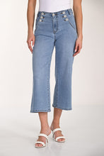 Load image into Gallery viewer, Light blue jeans with rhinestone button details and white sandals worn by a model on a white background.
