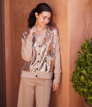 Load image into Gallery viewer, Woman wearing a sequined cardigan and beige pants standing against a peach-colored wall.
