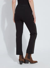 Load image into Gallery viewer, Model wearing black pants with bronze rhinestone accents and brown boots against a white background.
