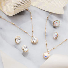 Load image into Gallery viewer, Gold and crystal jewelry set with crystal accents on a light gray surface.
