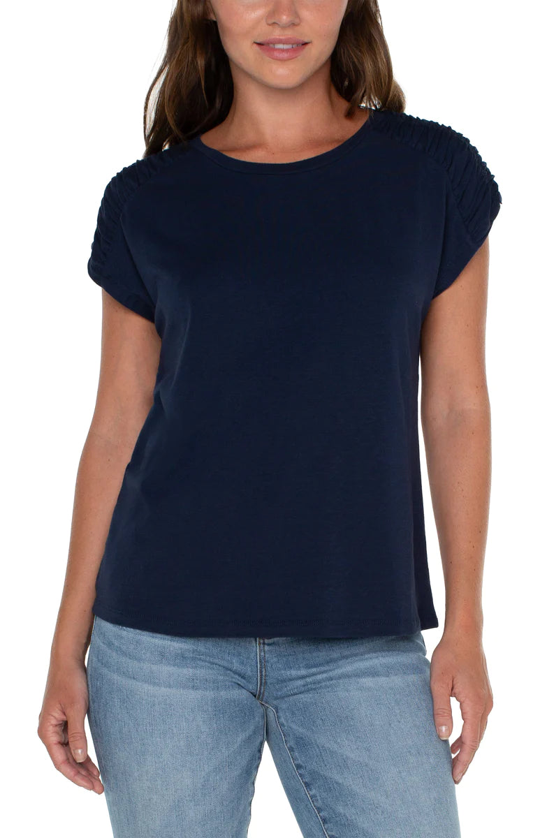 Make a statement in this essential raglan top. Featuring a sophisticated smocked shoulder detail that will certainly elevate your look. Add a touch of style to your wardrobe with this anything-but-basic knit top.  Color- Dark navy. Smocked shoulder detail. Short sleeves. Raglan sleeves. Scoop Neck.