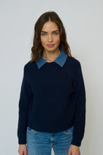 Load image into Gallery viewer, Woman wearing a navy sweater with a denim collar and blue jeans against a plain background.
