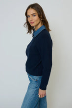 Load image into Gallery viewer, Woman wearing a navy sweater with a denim collar and blue jeans against a plain background.
