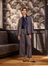 Load image into Gallery viewer, Woman wearing a plaid gray suit with a blue shirt in a room with decorative wall art.
