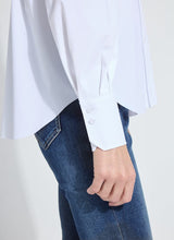 Load image into Gallery viewer, Model wearing a white long sleeve shirt and blue jeans against a plain background.

