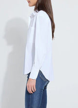 Load image into Gallery viewer, Model wearing a white long sleeve shirt and blue jeans against a plain background.
