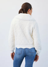 Load image into Gallery viewer, Woman wearing a creme jacket with textured pattern and blue jeans against a white background.
