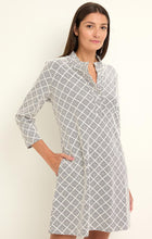 Load image into Gallery viewer, Woman wearing a black and white patterned dress against a plain background.
