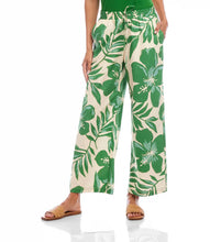 Load image into Gallery viewer, Tropical floral and leaf patterned pants worn by a person on a white background.
