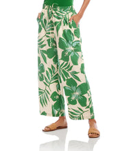 Load image into Gallery viewer, Tropical floral and leaf patterned pants worn by a person on a white background.
