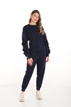 Load image into Gallery viewer, Woman wearing a navy blue outfit and white sneakers against a white background.
