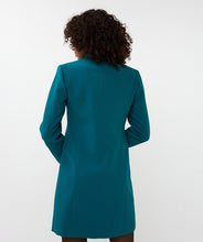 Load image into Gallery viewer, The back of a teal blazer dress worn by a model.
