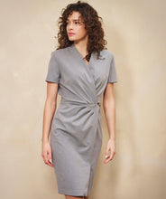 Load image into Gallery viewer, Woman wearing a gray cinched dress with silver buckle against a beige background.
