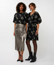 Load image into Gallery viewer, Models wearing a black and silver jacquard puff sleeve top, long silver skirt and heels and a black and silver puff sleeve jacquard dress and black boots against a white background.
