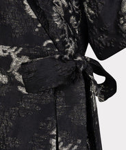 Load image into Gallery viewer, Close-up of side tie on black and silver floral print dress against a white background.
