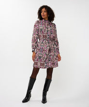 Load image into Gallery viewer, Woman wearing a zebra patterned dress and tall black boots against a white background.
