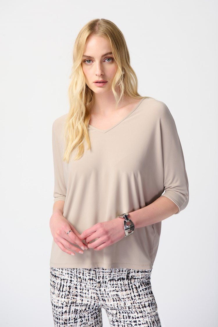 Discover the versatility of this reversible top, featuring a V-shaped neckline on one side and a round collar on the other. Perfect for any occasion, the contemporary design allows for effortless styling. With three-quarter dolman sleeves for added elegance and a relaxed fit, this top is both comfortable and chic.