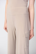 Load image into Gallery viewer, This sleek, silky knit wide-leg pant showcases a flared silhouette that effortlessly goes from day to night. Featuring a button closure and a soft contour waistband for added comfort, this look also includes cargo pockets highlighting this piece’s polished style.  Color- Dune. Silky knit. Soft contour waistband. Cargo pockets. Unlined.
