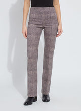 Load image into Gallery viewer, Model wearing patterned pants, black top and black boots against a white background.
