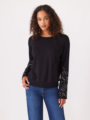 The Eliana Embellished Sleeve Top by Karen Kane is a fashionable and cozy top with long sleeves embellished with glittering gems, lending a sophisticated touch to any ensemble.