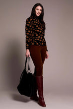 Load image into Gallery viewer, Woman wearing a black velvet with tonal flowers top, brown pants with burgundy boots and carrying a black bag against a plain background.
