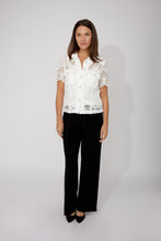 Load image into Gallery viewer, Woman wearing an off-white blouse with heart embroidery and rhinestone heart buttons and black pants against a white background.
