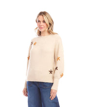 Load image into Gallery viewer, Woman wearing a cream sweater with embroidered flowers and blue jeans against a white background.
