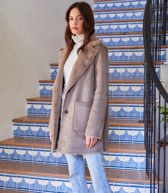 A fold over collar shows off the cozy faux-fur lining of this polished coat that is outfitted with patch pockets for even more warmth. Color- Taupe. Patch pockets. Button down. Faux fur. Fabric- 100% Polyester. Care- Dry clean.